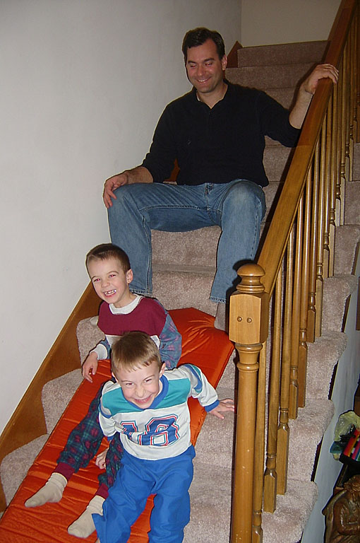 Todd and Joel have fun sliding down the steps on an air mattress with Alan.