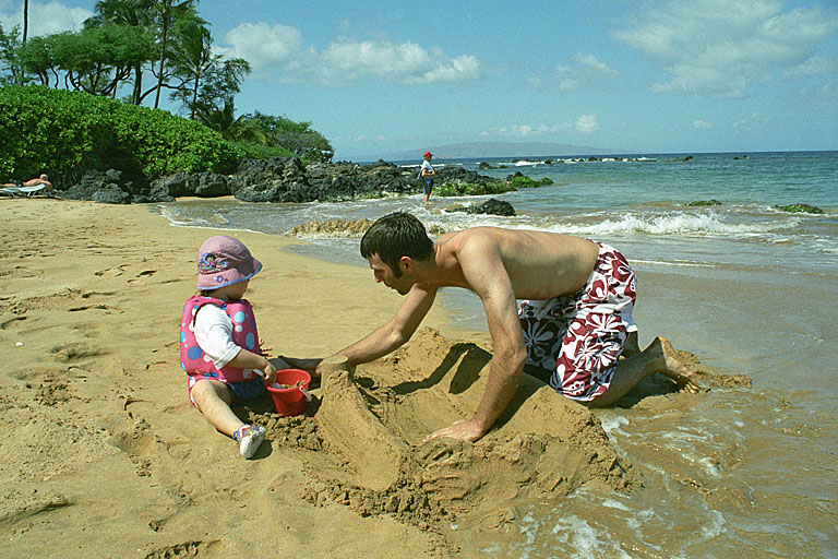 Dan and Sarah trying to build a sand castle while the waves try to take it away.