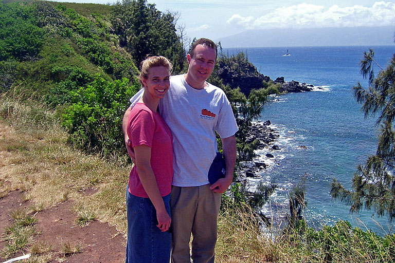 Laurie and Chad smile with a neat sailboat in the background.