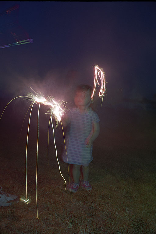 Sarah starts a little fire in the yard with her sparkler.