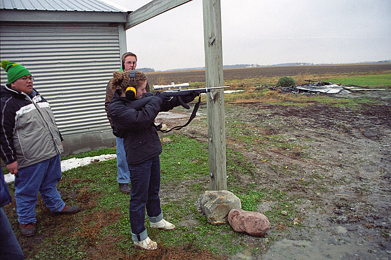 Leo and Abe wonder what Kristi is listening to on her headphones while she shoots. I think she likes firearms a little too much.