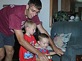 Dan pushs Joel and Todd around on their new tricycle.