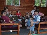Dan, Laurie, Chad (hidden) team up against Craig, Tammy, and Mom for a game of Trivial Pursuit.  Joel and Todd want to go swimming.