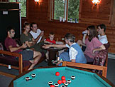 Mom tries to keep the board on the table as Joel plays with the pieces.