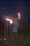 Sarah starts a little fire in the yard with her sparkler.
