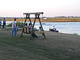 Chad pushes Sarah on the swing.  Todd waits for his turn.