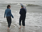 Katy laughs with Beth about the futility of such a small umbrella, but what do they care, they are on the beach.