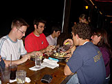 Abe, Dan, Kyle, Jon, and Erica pass the time by playing cards for crackers.