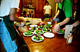 Dan shows Mark and Kyle how he wants the salads made.
