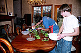 Kyle tops the salad with cheese and Jonathan adds the cranberries.