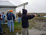 Jeremy shoots the old police issue.  Katy, Blessing, Dan, Klayton, and Abe laugh at the massive hole Abe just put in a can.