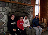 Evan Fritz, Alyssa Klopfenstein, Tyler Stieglitz, and Phil Huber warm up by the fire before hitting the slopes again.